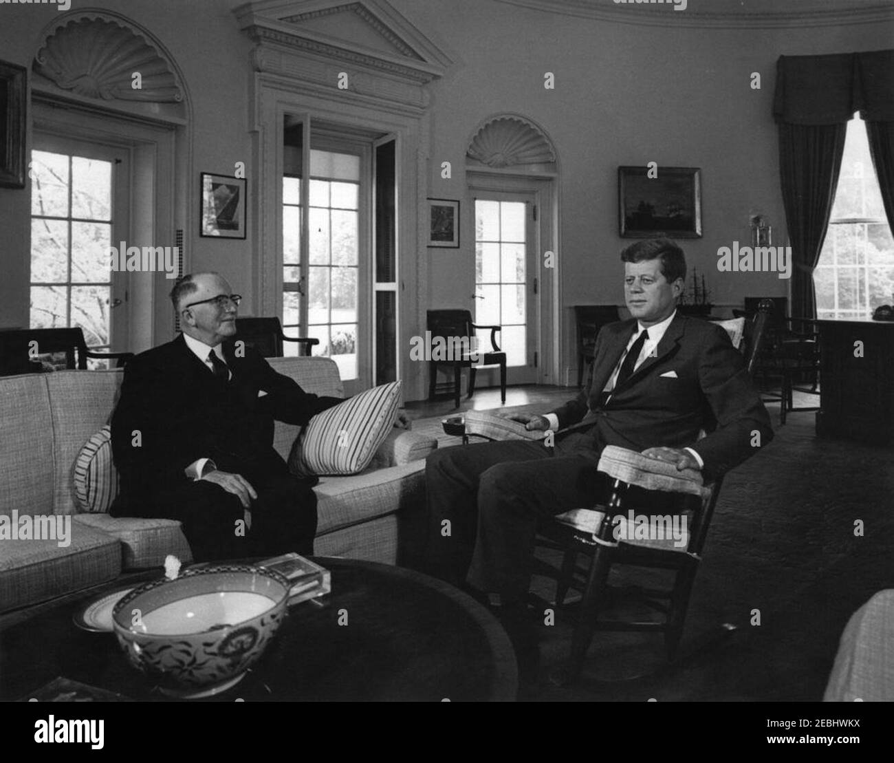 Incontro con H. Ladd Plumley, presidente della Camera di Commercio degli Stati Uniti, alle 10:37. Il presidente John F. Kennedy (in sedia a dondolo) incontra il presidente della Camera di Commercio degli Stati Uniti, H. Ladd Plumley. Ufficio ovale, Casa Bianca, Washington, D.C. Foto Stock