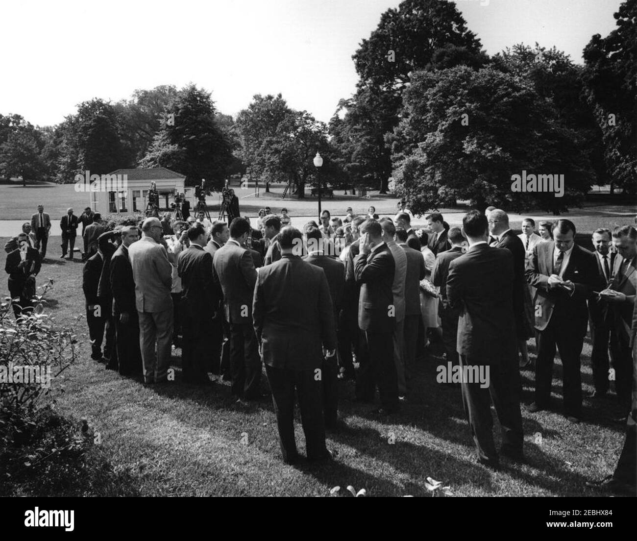 Visita della scuola superiore di Glen Lake (Michigan), 9:50. Il presidente John F. Kennedy (centro, a sinistra) saluta la Glen Lake High School (Maple City, Michigan), studente di classe senior, Duane Richardson (in profilo, per lo più nascosto), sul prato dell'ala ovest della Casa Bianca. Il sig. Richardson e i suoi compagni di classe hanno visitato Washington, D.C., in un viaggio finanziato da donazioni dopo che il gruppo ha dato i fondi originali per aiutare a pagare le spese mediche del sig. Richardsonu0027s. Anche nella foto: Rappresentante Ken Hechler (West Virginia); rappresentante Robert P. Griffin (Michigan); corrispondente della Casa Bianca per la Nazione Foto Stock