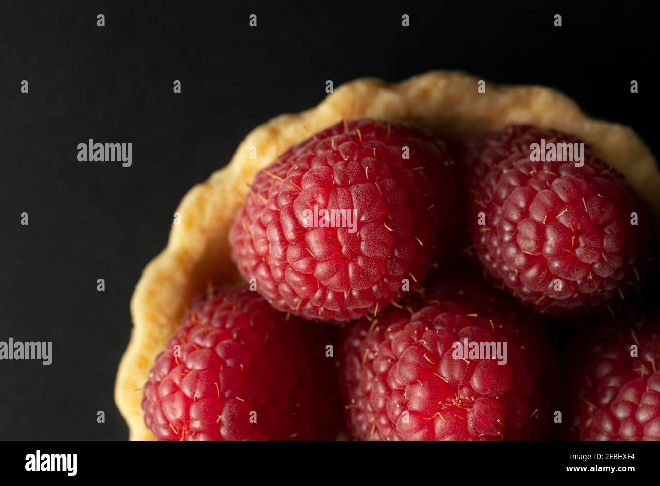 Crostata di lamponi, foto macro con vista dall'alto. Crostata di lamponi fatta in casa su sfondo nero. Foto Stock