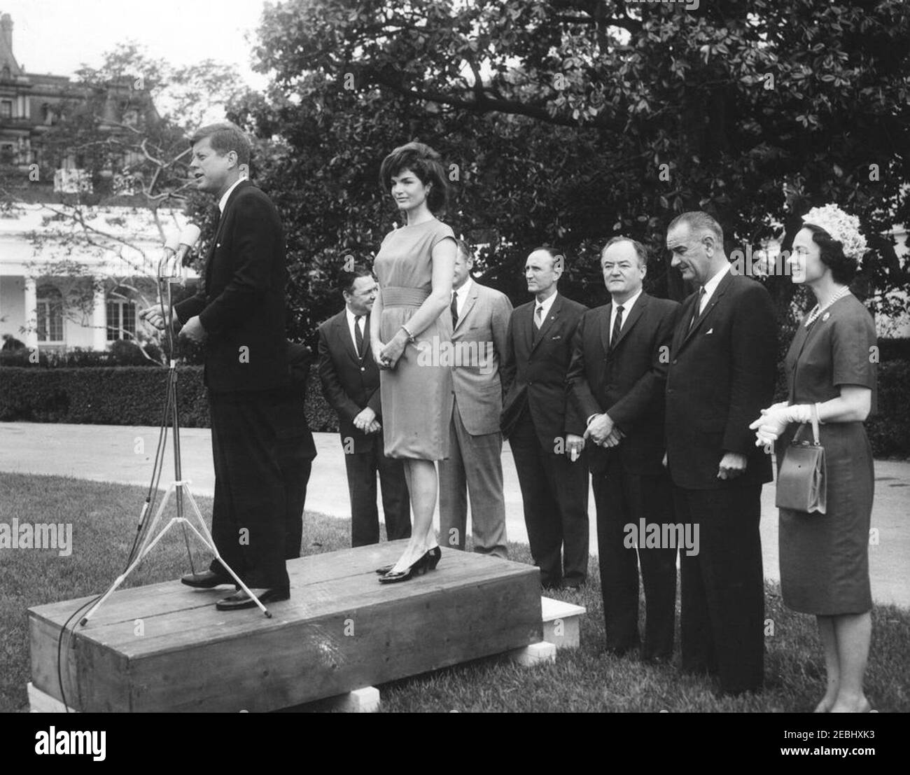 Visita dei partecipanti alla Conferenza della Campagna 1962 per le Donne democratiche, alle 9:35. Il presidente John F. Kennedy fa un commento ai partecipanti alla Conferenza sulla Campagna per le Donne democratiche del 1962. Da sinistra a destra: Presidente Kennedy; Rappresentante Hale Boggs (Louisiana); First Lady Jacqueline Kennedy; Senatore George Smathers della Florida (parzialmente nascosto); Senatore Mike Mansfield (Montana); Senatore Hubert H. Humphrey (Minnesota); Vice Presidente Lyndon B. Johnson; Vice Presidente del Comitato Nazionale democratico (DNC), Margaret B. Price. South Lawn, Casa Bianca, Washington, D.C. Foto Stock