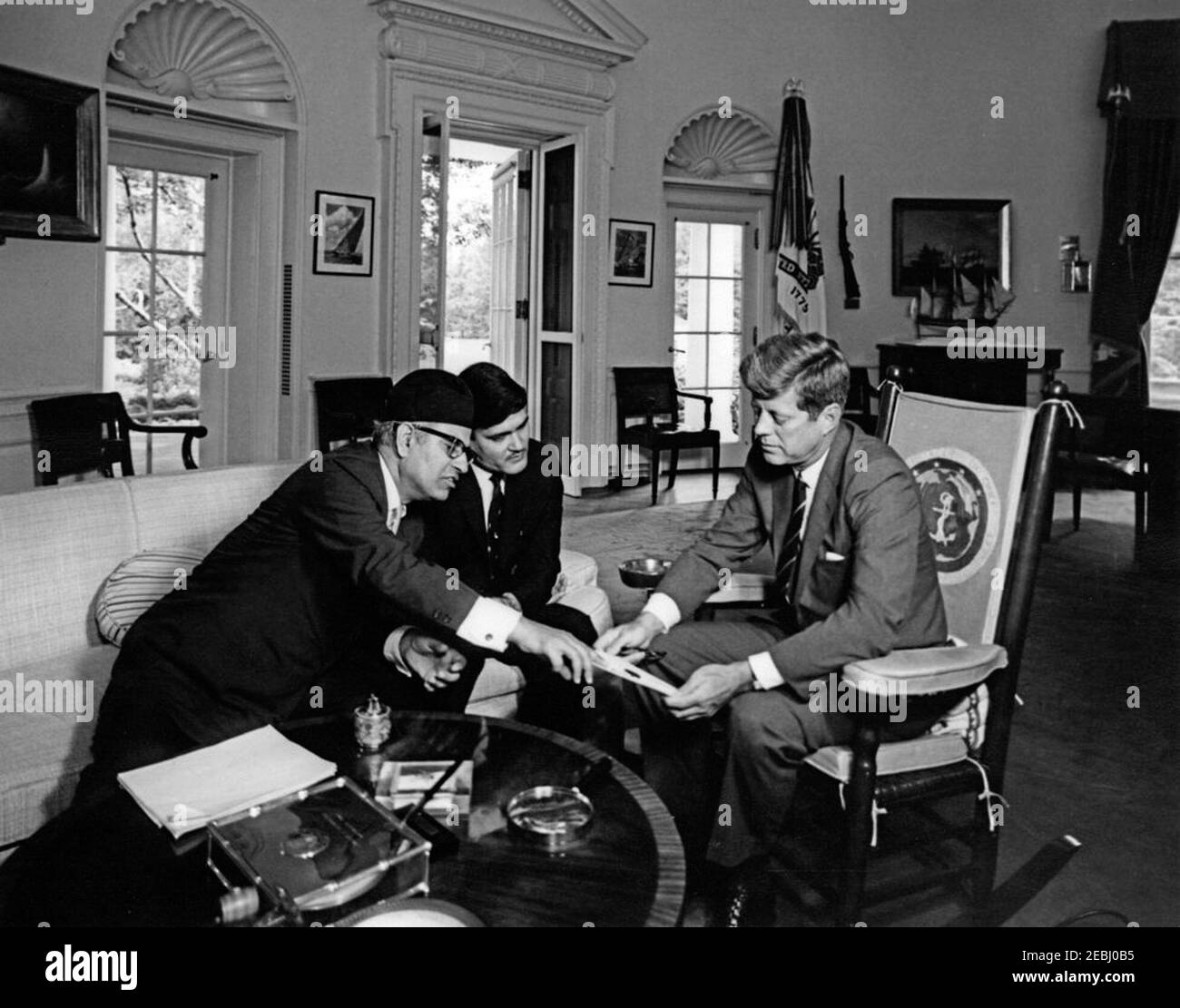Incontro con Tulsi Giri, Presidente del Consiglio dei Ministri del Nepal, ore 10. Il presidente John F. Kennedy (in sedia a dondolo a destra, con un documento e un paio di occhiali) incontra il presidente del Consiglio dei ministri del Nepal, il dottor Tulsi Giri; l'ambasciatore del Nepal, Matrika Prasad Koirala (che indica il documento nelle mani del presidente Kennedyu0027s), siede a sinistra. Ufficio ovale, Casa Bianca, Washington, D.C. Foto Stock
