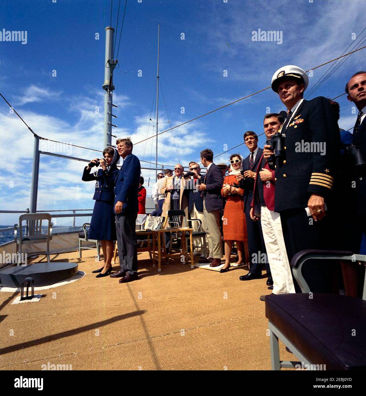 Il presidente Kennedy si accuda alla prima gara di Coppa Americau0027s. Il presidente John F. Kennedy e la First Lady Jacqueline Kennedy (entrambi a sinistra) guardano la prima gara della Americau0027s Cup 1962 a bordo della USS Joseph P. Kennedy, Jr. Anche nella foto: Hugh D. Auchincloss; sotto il segretario della Marina, Paul u0022Redu0022 Fay; Jamie Auchincloss; Janet Auchincloss; John Forbes Kerry; Segretario della stampa, Pierre Salinger; Naval Aide al presidente, Capitano Tazewell Shepard; Rappresentante Fernand St. Germain (Rhode Island). Newport, Rhode Island. Foto Stock