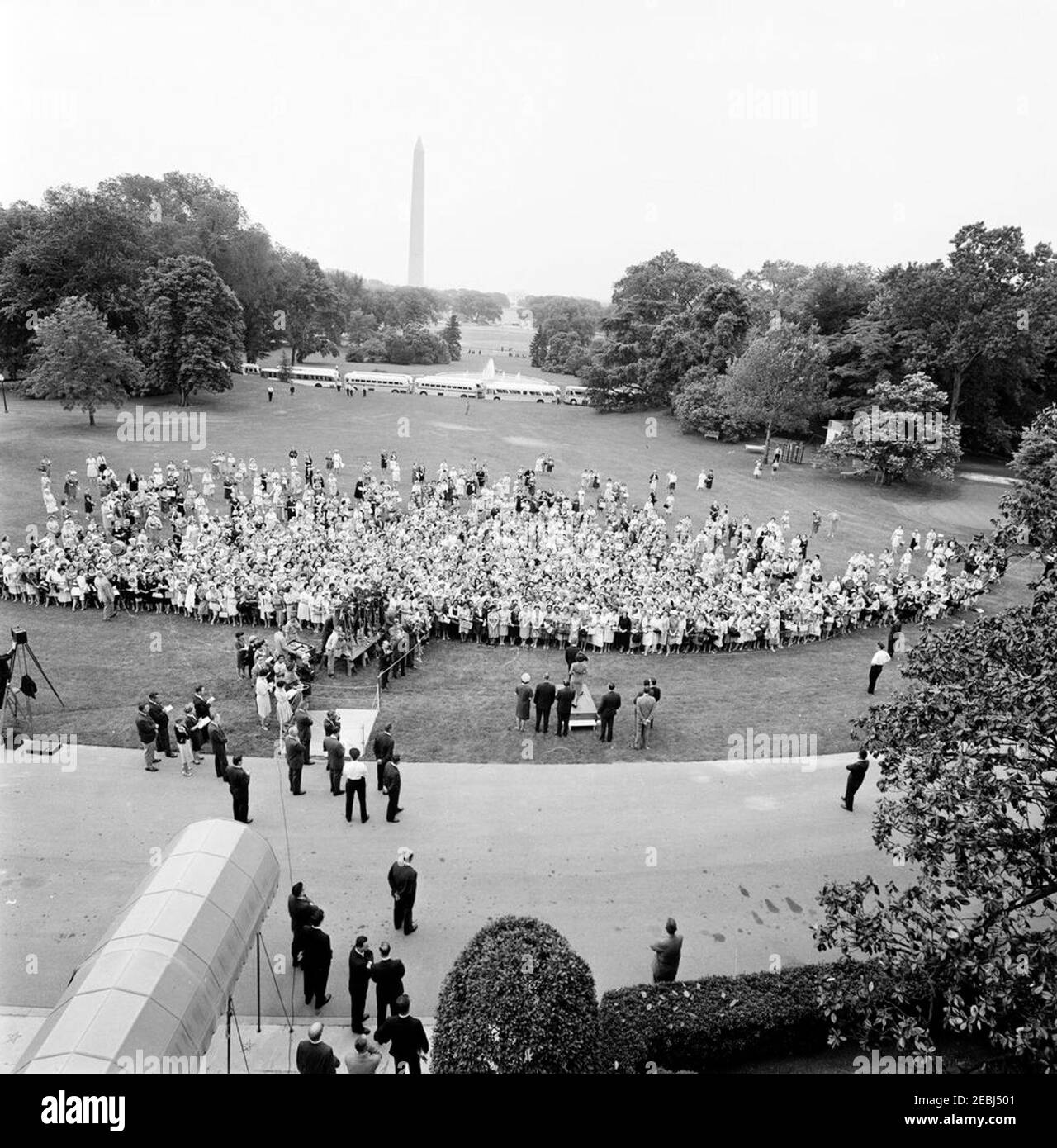 Visita dei partecipanti alla Conferenza della Campagna 1962 per le Donne democratiche, alle 9:35. Visita dei partecipanti alla Conferenza della Campagna 1962 per le Donne democratiche; il Presidente John F. Kennedy e la First Lady Jacqueline Kennedy si trovano sulla piattaforma (al centro). Nella foto sono inoltre raffigurati: Vicepresidente del Comitato Nazionale democratico (DNC), Margaret B. Price; Vicepresidente Lyndon B. Johnson; Senatore Hubert H. Humphrey (Minnesota); Senatore Mike Mansfield (Montana); Senatore George Smathers (Florida); Rappresentante Hale Boggs (Louisiana); Rappresentante Carl Albert (Oklahoma); corrispondente di Washington per il Guy Foto Stock