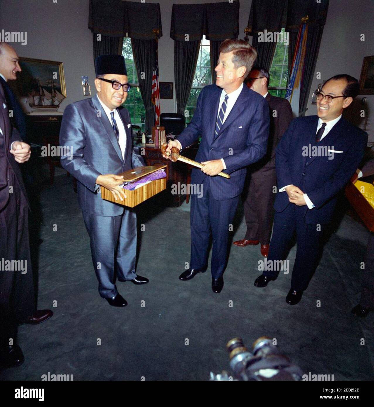 Incontro con Tun Abdul Razak, Vice primo Ministro della Malaya, 11:58. Il presidente John F. Kennedy scambia regali con il vice primo ministro e ministro della Difesa della Malaya, Tun Abdul Razak Hussein, durante un incontro nell'ufficio ovale. Da sinistra a destra: Vice Capo del protocollo degli Stati Uniti, William J. Tonesk (sul bordo della cornice); Tun Razak; Presidente Kennedy; Vice Segretario di Stato degli Stati Uniti per gli Affari dell'Estremo Oriente, Roger Hilsman (dietro il presidente); Ambasciatore della Malaya, Omar ONG Gioke Lin. White House, Washington, D.C. [vedi anche MO 74.334a-b, u0022Jeweled kris e sheathu0022] Foto Stock