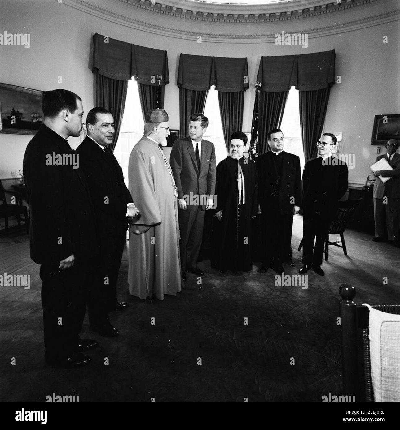 Incontro con Paul Boutros Meouchi, Patriarca della Chiesa Maronita, Libano, ORE 12:03. Il Presidente John F. Kennedy incontra il Patriarca libanese della Chiesa Maronita Paul Boutos Meouchi. Da sinistra a destra: Un sacerdote non identificato; l'ambasciatore del Libano, Ibrahim al-Ahdab; il Patriarca Meouchi; il presidente Kennedy; il vescovo Antoine Pierre Khoraiche; due sacerdoti non identificati; e l'assistente speciale al presidente, Dave Powers. Anche elencato nel calendario del Presidente 0027s: Segretario al Patriarca Khalil Abi-Nader; Monsingor Joseph Feghali; e Monsignor Joseph Eid. Ufficio ovale, Casa Bianca, Washington Foto Stock