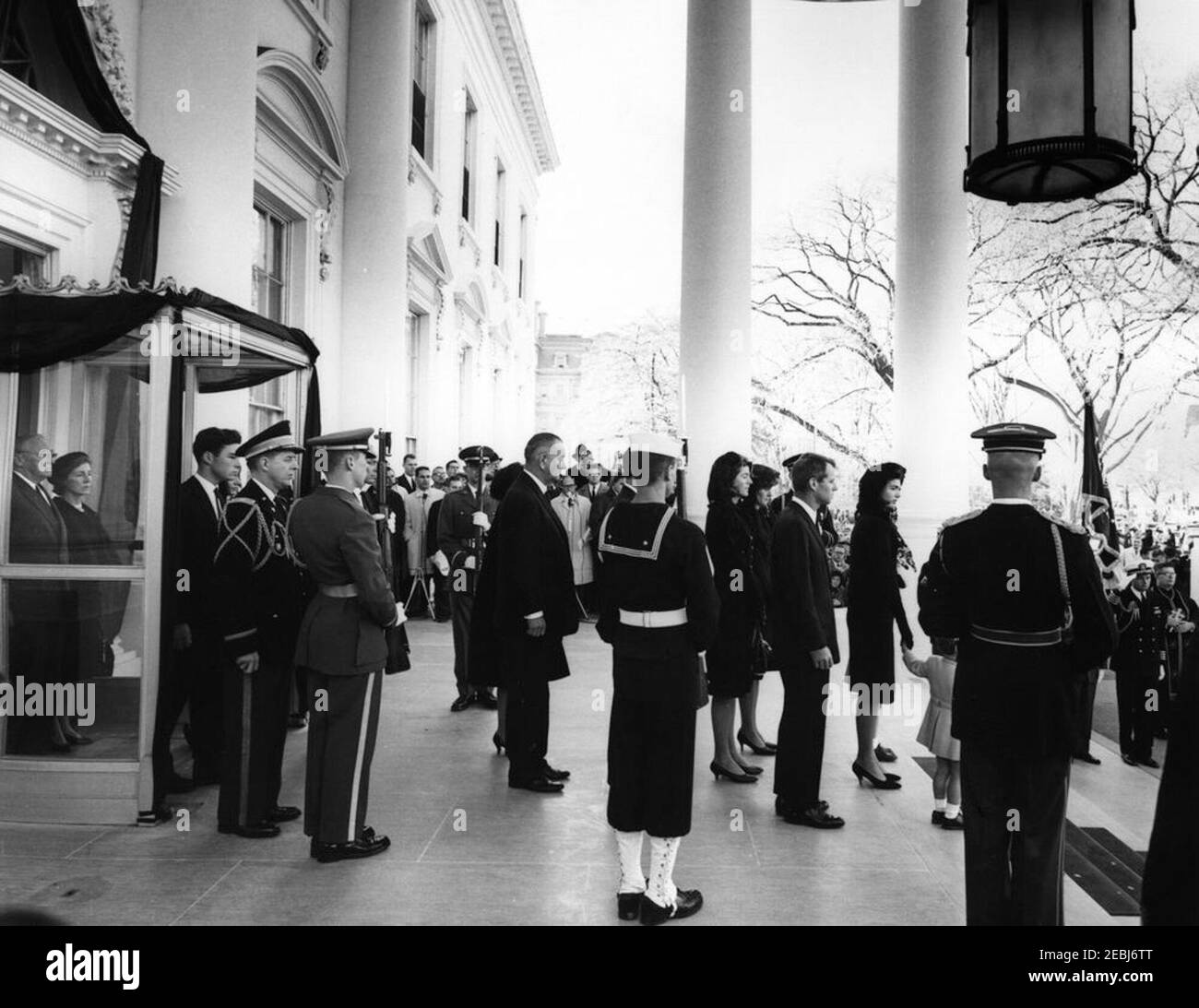 Funerale di Stato del Presidente Kennedy: Partenza dalla Casa Bianca e Processione al Campidoglio degli Stati Uniti. Jacqueline Kennedy si trova con i suoi figli, Caroline Kennedy e John F. Kennedy, Jr., nel Portico Nord, prima della processione funebre del presidente John F. Kennedy dalla Casa Bianca al Campidoglio. Alle spalle della Sig.ra Kennedy: Avvocato generale, Robert F. Kennedy; Jean Kennedy Smith; Patricia Kennedy Lawford; presidente Lyndon B. Johnson; principessa Lee Radziwill di Polonia; Jamie Auchincloss; Janet Auchincloss; Hugh D. Auchincloss; agente di Servizio segreto della Casa Bianca, Ru Foto Stock