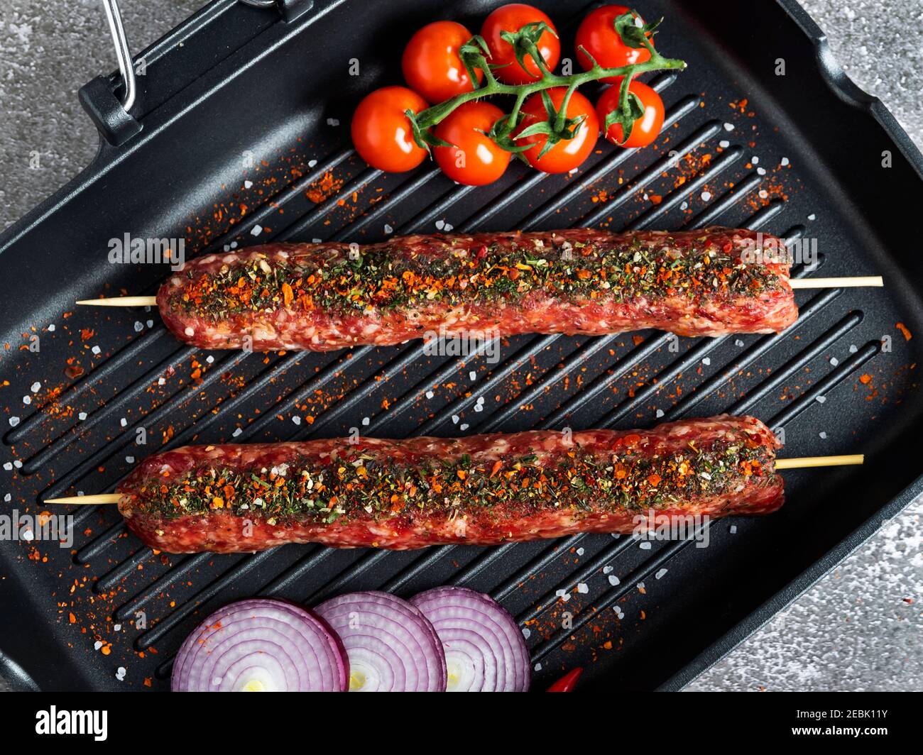 lula kebab carne di manzo cruda su grill padella, spezie, vista dall'alto, primo piano Foto Stock