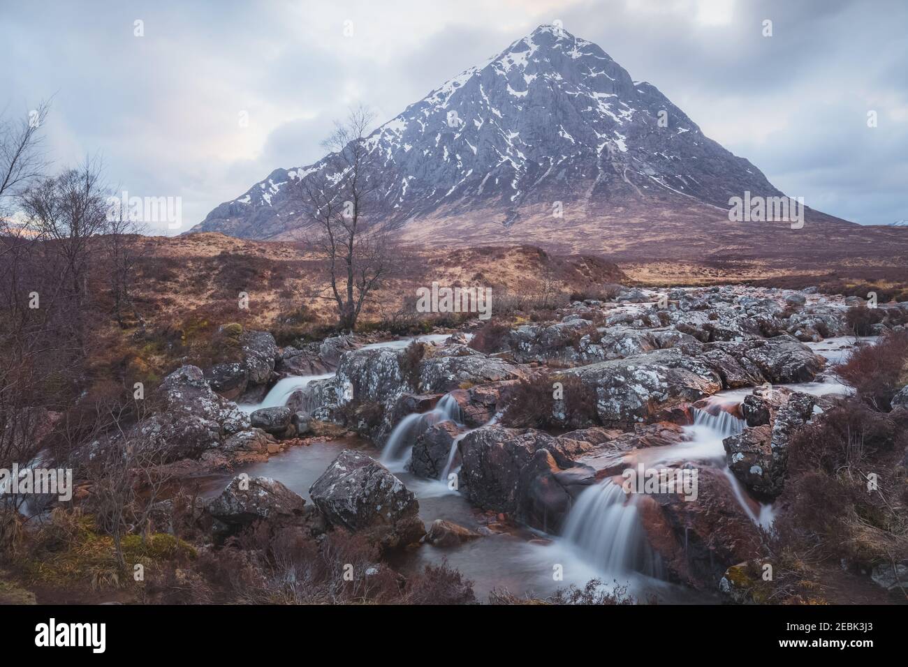 Moody paesaggio dell'iconica Buachaille Etiv Mor e cascata del fiume Coupall a Glencoe nelle Highlands scozzesi. Foto Stock