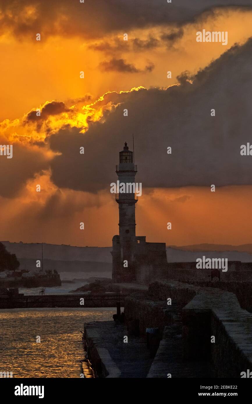 Porto veneziano storico e faro a la Canea sulla costa nord-occidentale dell'isola greca di Creta in una luce tramonto incandescente. Foto Stock