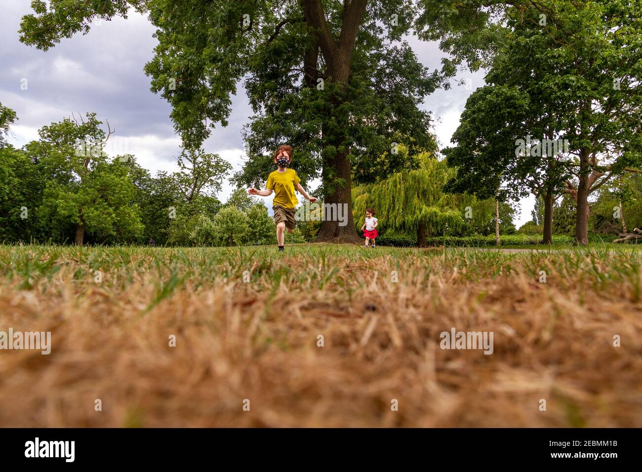 Due bambini che corrono nel parco in un'estate soleggiata giorno Foto Stock