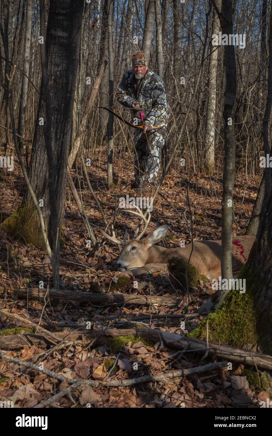 Hunter tiene il suo arco e freccia ricorsi fatti su misura mentre si avvicina alla sua uccisione nel Wisconsin settentrionale. Foto Stock