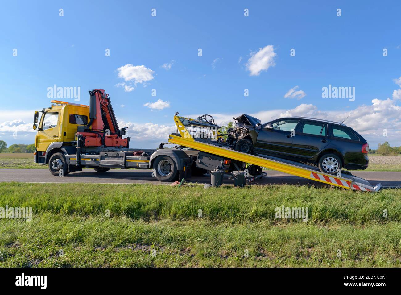Dopo un incidente, l'auto in crash viene tirata su un carrello di traino Foto Stock