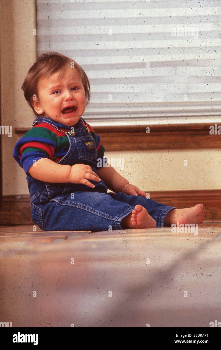 Il bambino anglo di otto mesi impara a strisciare sul pavimento ed è infelice. VERSIONE DEL MODELLO EI-0000 ©Bob Daemmrich Foto Stock