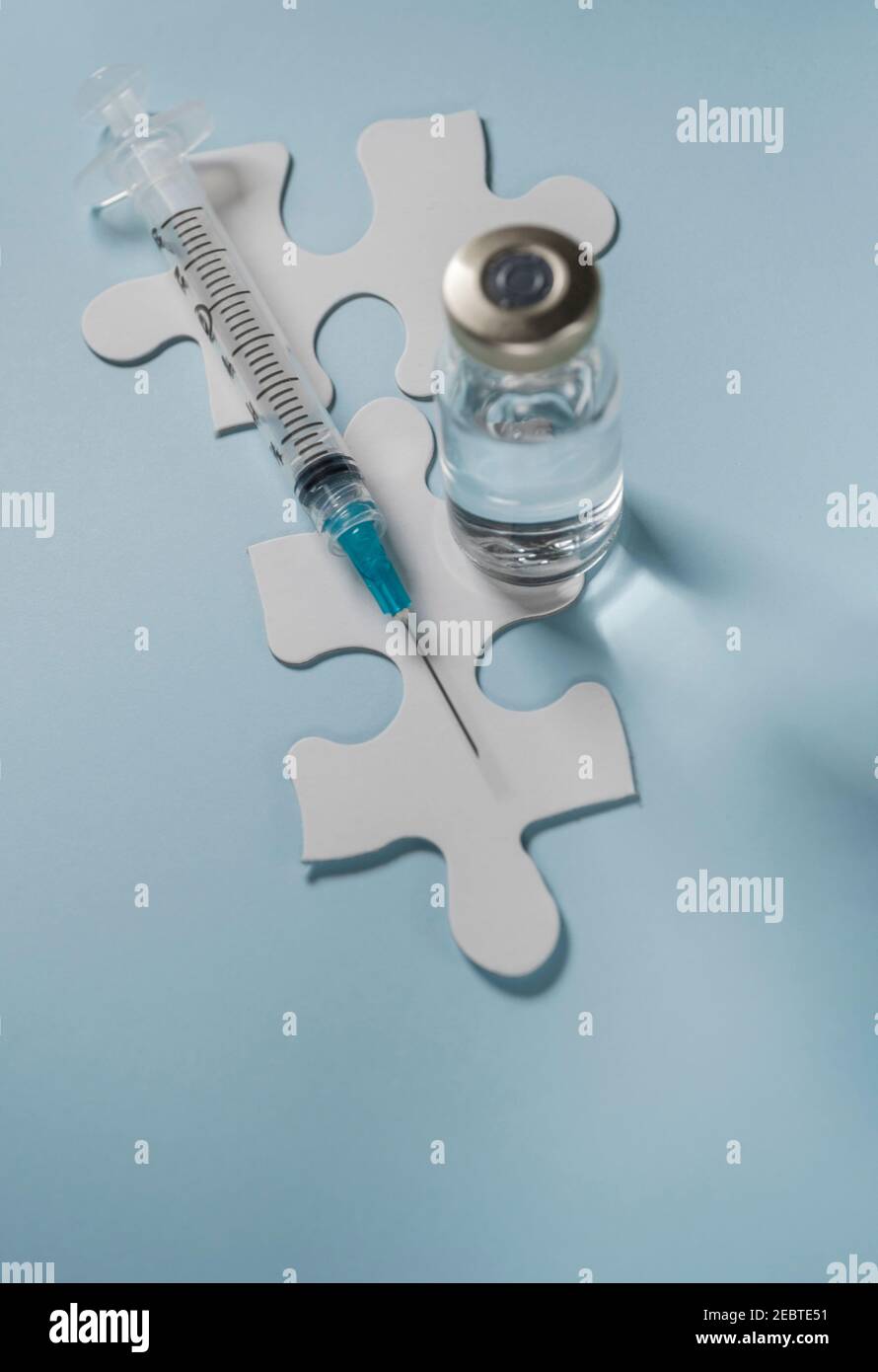Flaconcino di vaccino Covid-19 e siringa su puzzle Foto Stock