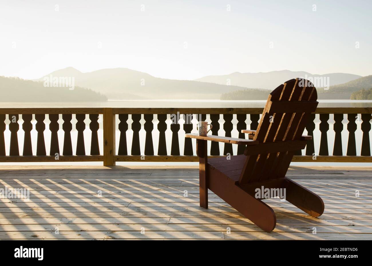 USA, New York, Lake Placid, sedia Adirondack sul ponte vicino al lago Foto Stock