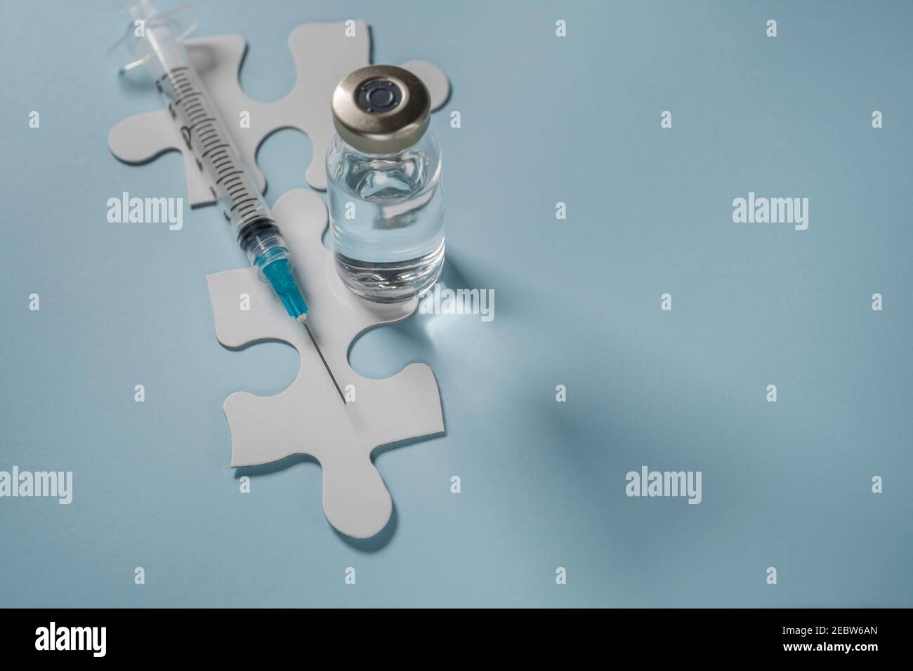 Flaconcino di vaccino Covid-19 e siringa su puzzle Foto Stock