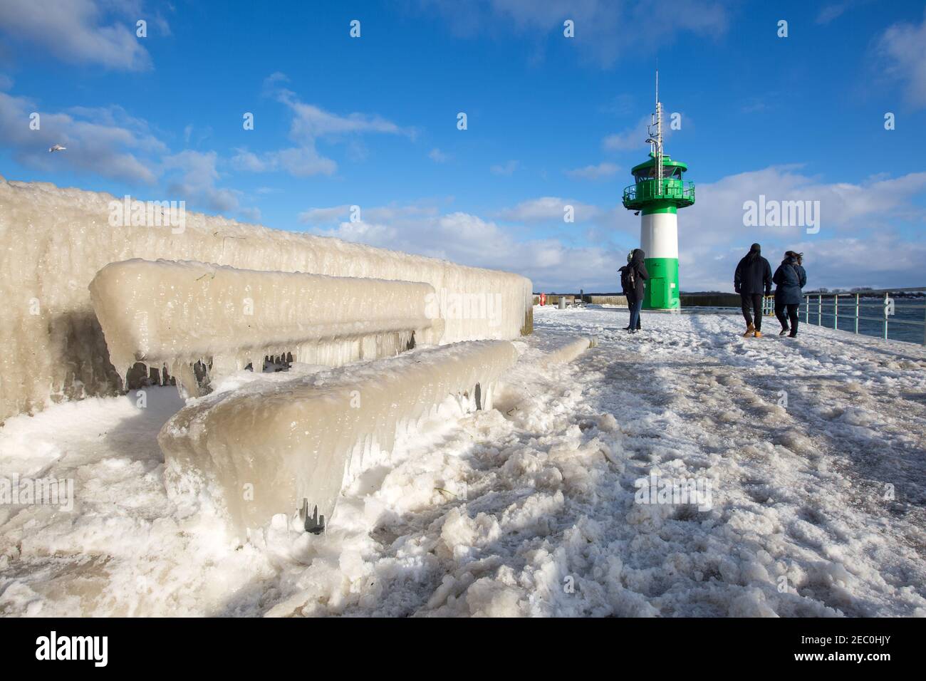 Gefrorenes Meerwasser ist an der Mole vom Leuchtturm Travemünde in Lübeck-Travemünde zu sehen. Foto Stock