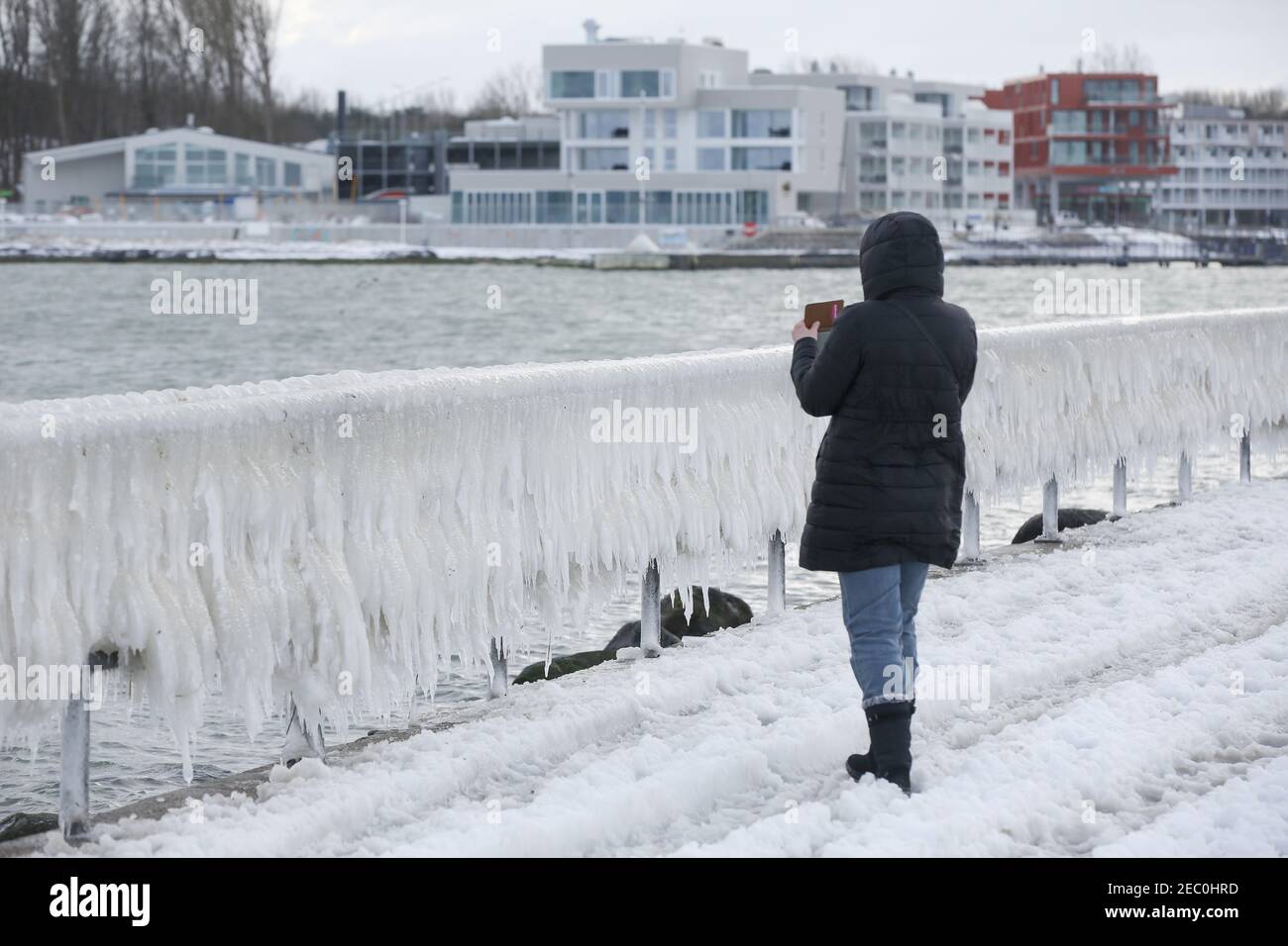 Gefrorenes Meerwasser ist an der Mole vom Leuchtturm Travemünde in Lübeck-Travemünde zu sehen. Foto Stock