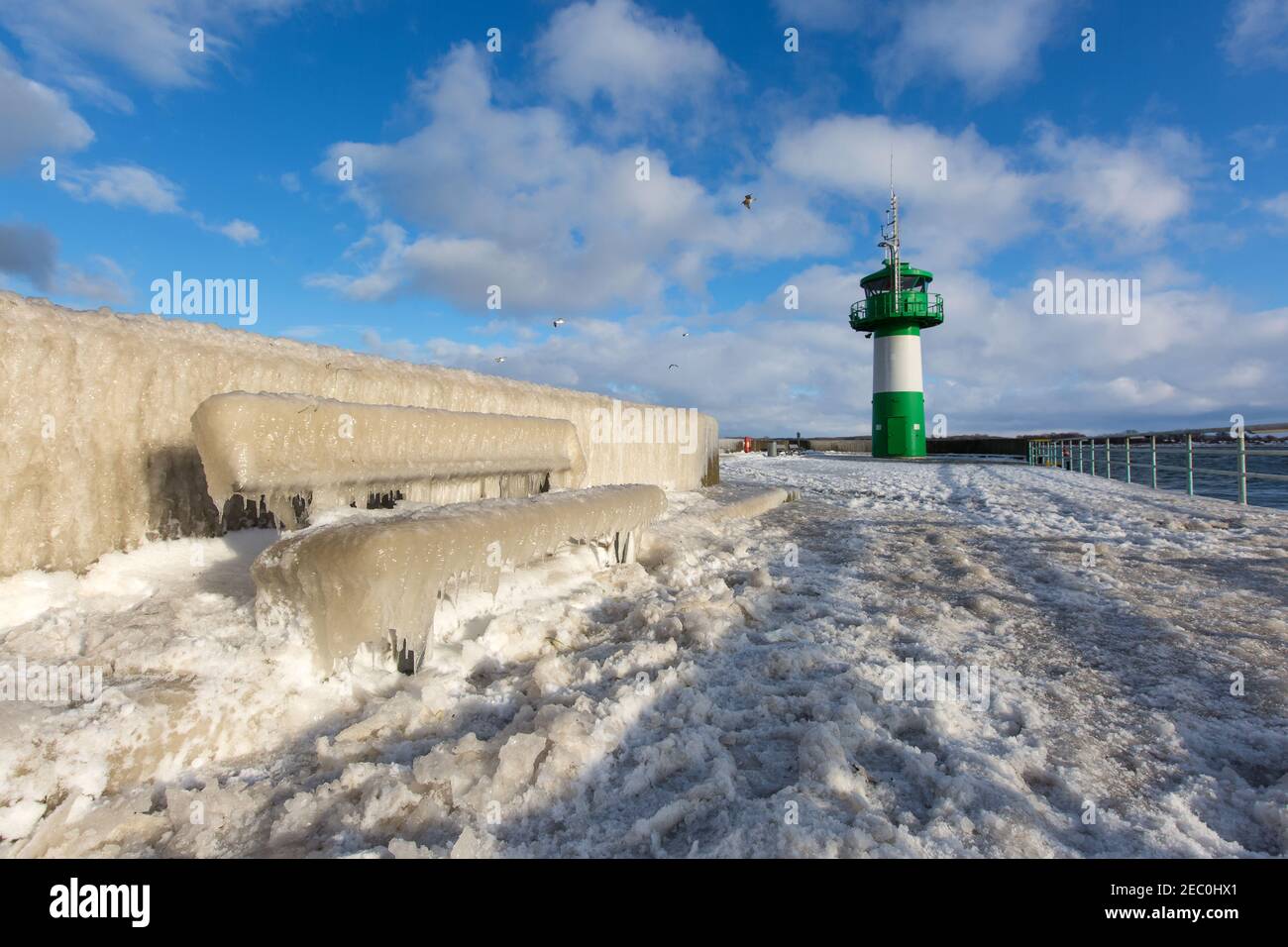 Gefrorenes Meerwasser ist an der Mole vom Leuchtturm Travemünde in Lübeck-Travemünde zu sehen. Foto Stock