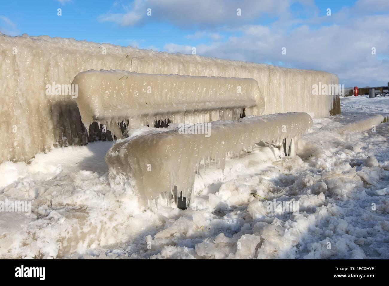 Gefrorenes Meerwasser ist an der Mole vom Leuchtturm Travemünde in Lübeck-Travemünde zu sehen. Foto Stock