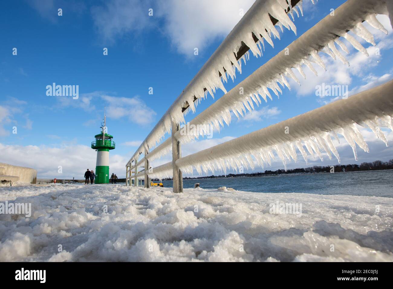 Gefrorenes Meerwasser ist an der Mole vom Leuchtturm Travemünde in Lübeck-Travemünde zu sehen. Foto Stock