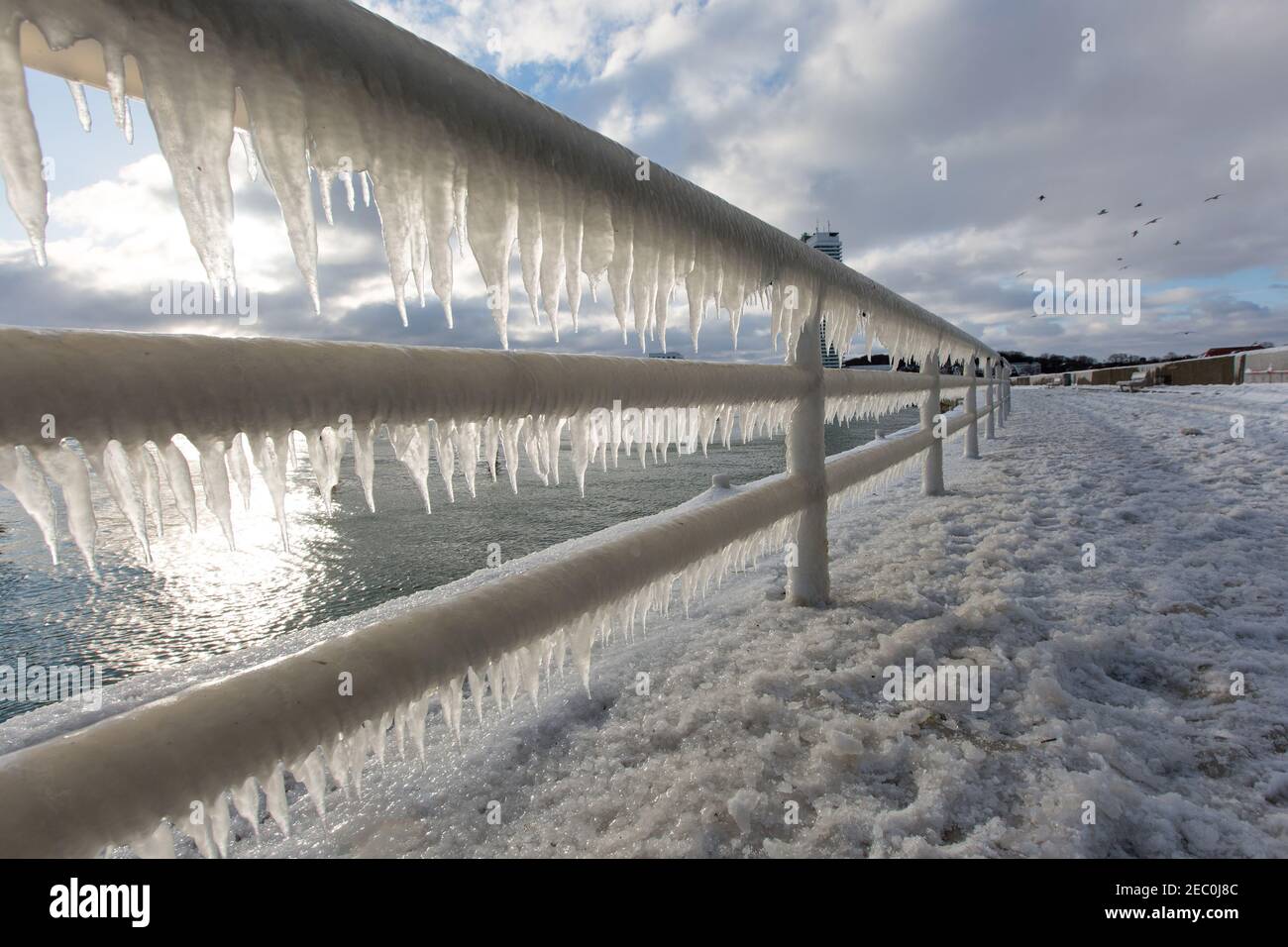 Gefrorenes Meerwasser ist an der Mole vom Leuchtturm Travemünde in Lübeck-Travemünde zu sehen. Foto Stock