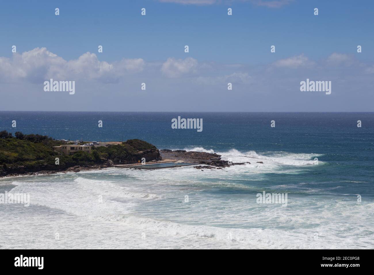 La piscina di Mona vale Beach offre viste sull'oceano, sull'orizzonte e sulla scogliera in lontananza Foto Stock