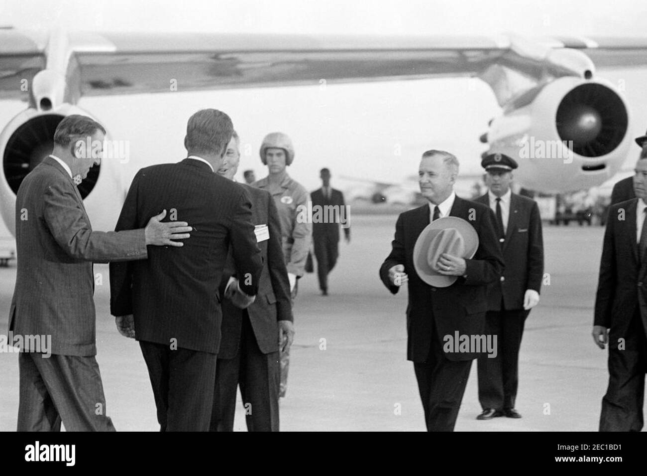 Visita delle installazioni della NASA: Houston, Texas, arrivo, 18:15. Il presidente John F. Kennedy (ritorno alla macchina fotografica) saluta il sindaco di Houston, Texas, Lewis Cutro, all'arrivo all'aeroporto internazionale di Houston, Houston, Texas. Da sinistra a destra (in primo piano): Rappresentante Albert Thomas (Texas); presidente Kennedy; sindaco Cutro (parzialmente nascosto, scuotendo le mani con il presidente); governatore del Texas, Price Daniel (cappello); giudice della contea di Harris, Bill Elliott (per lo più fuori dal telaio). Il presidente Kennedy si è recato a Houston come parte di un tour di due giorni di ispezione dell'astronautica nazionale e dell'astronomo spaziale Foto Stock