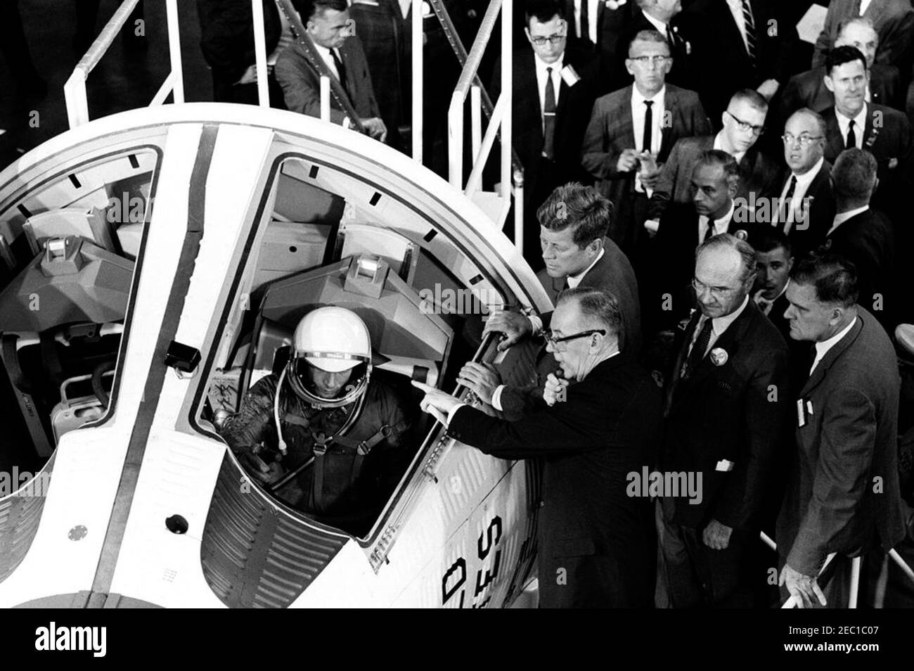 Visita delle installazioni della NASA: St. Louis, Missouri, McDonnell Aircraft, 15:27. Il presidente John F. Kennedy vede un mock-up della capsula spaziale Gemini, durante un tour della McDonnell Aircraft Corporation Plant a St. Louis, Missouri. Da sinistra a destra (in primo piano): Ingegnere McDonnell, Elbert Wiegand (seduto nell'abitacolo della navicella spaziale a due uomini); Vice Presidente della McDonnell Aircraft Corporation e Direttore Generale dei progetti Mercury e Gemini, Walter F. Burke (parlando al microfono); Presidente Kennedy; Presidente del Consiglio di Amministrazione e Amministratore Delegato della McDonnell Aircraft Co Foto Stock