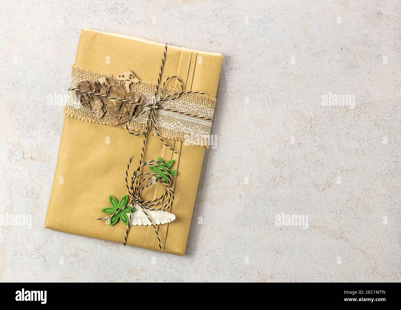 Libro avvolto in carta artigianale con decorazioni in legno. Nessun spreco, confezione eco-compatibile regalo. Foto Stock
