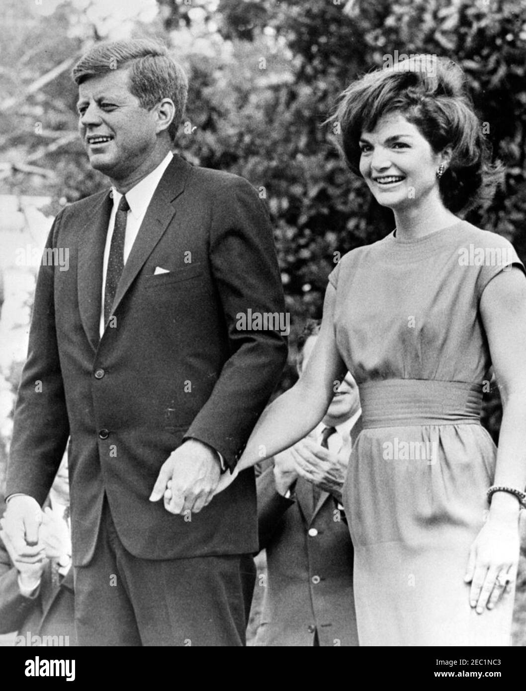Visita dei partecipanti alla Conferenza della Campagna 1962 per le Donne democratiche, alle 9:35. Il presidente John F. Kennedy e la First Lady Jacqueline Kennedy si levano su una piattaforma speakersu2019 durante una visita con i partecipanti alla Conferenza della Campagna per le Donne democratiche del 1962. South Lawn, Casa Bianca, Washington, D.C. Foto Stock