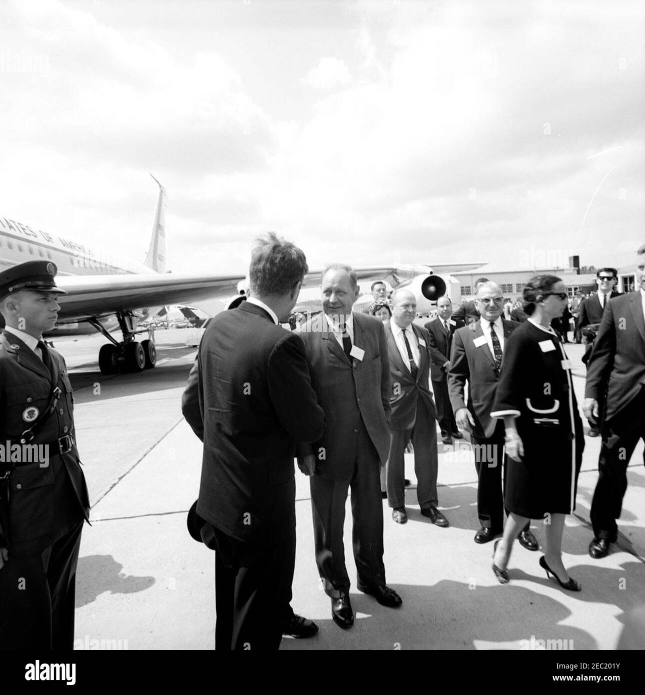 Indirizzo di inizio alla United States Military Academy, West Point (New York), 10:01. Il presidente John F. Kennedy (centro a sinistra, di nuovo alla macchina fotografica) visita con i leader democratici della contea di Orange, New York, prima della sua partenza per Washington, D.C., dopo aver frequentato gli esercizi di laurea alla United States Military Academy, West Point, New York. I saluti del presidente Kennedy includono: Lawrence E. Maxwell; Joan Greaves; Edwin R. Kaback; George J. Manuche; B. Sears Hunter. Air Force One è visibile all'estrema sinistra. Base dell'aeronautica militare Stewart, Newburgh, New York. Foto Stock