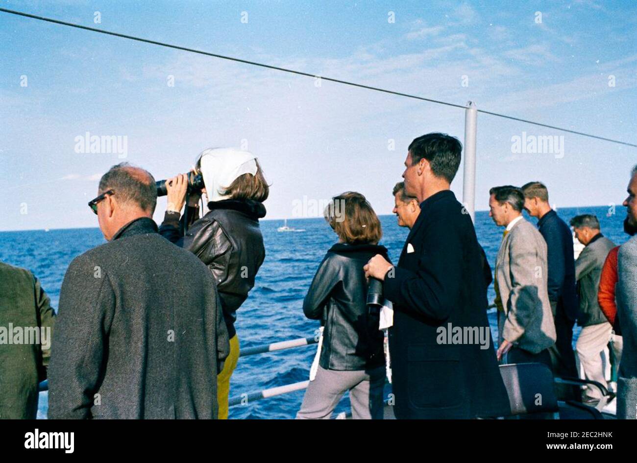 Il presidente Kennedy guarda la quarta gara della Coppa Americau0027s. Il presidente John F. Kennedy e la First Lady Jacqueline Kennedy (entrambi al centro) guardano la quarta gara della Americau0027s Cup 1962 a bordo della USS Joseph P. Kennedy, Jr., al largo della costa di Newport, Rhode Island. Lo scrittore George Plimpton si trova a destra; altri non sono identificati. Foto Stock