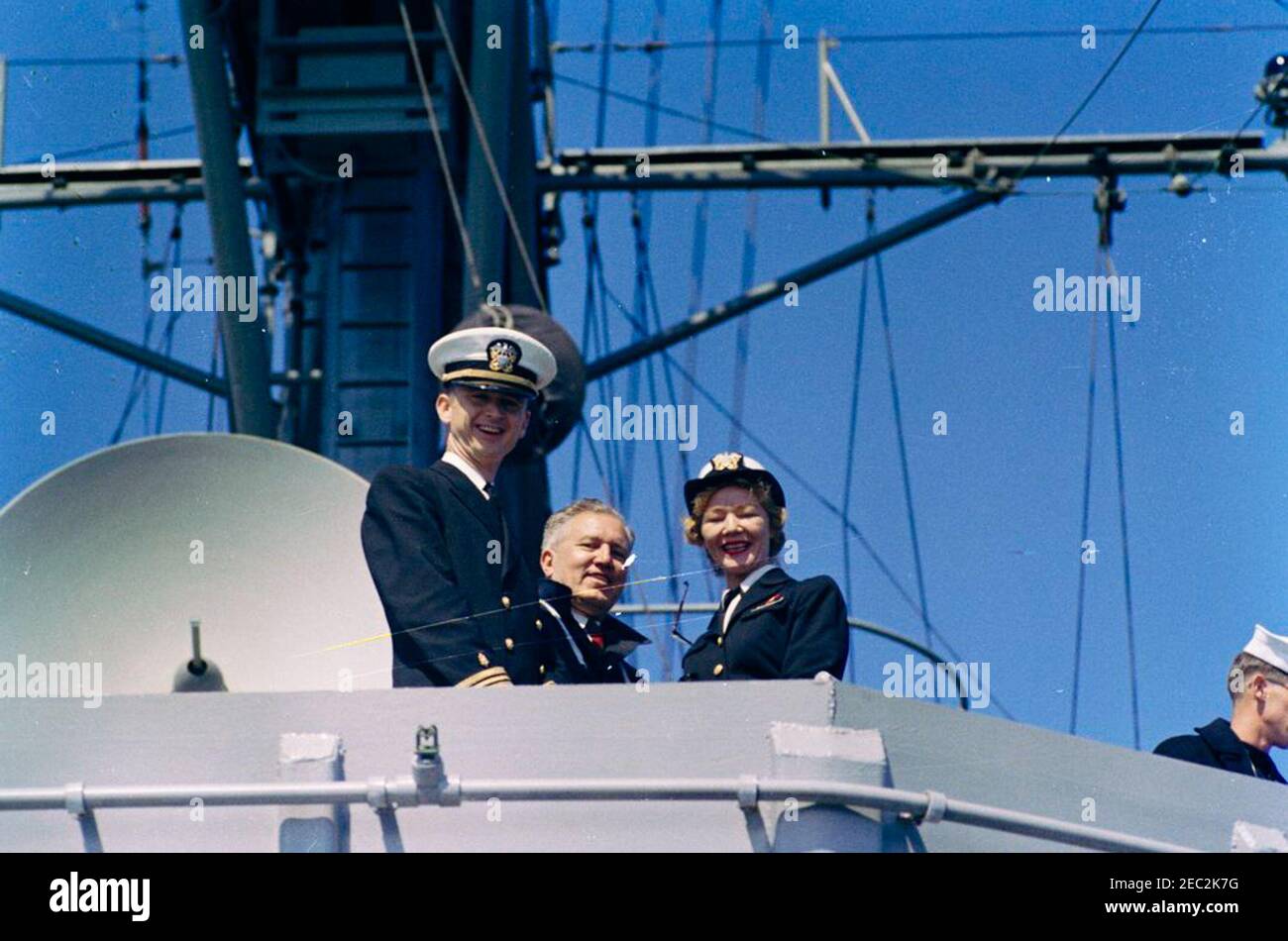 Il presidente Kennedy guarda la quarta gara della Coppa Americau0027s. Assistente medico al presidente John F. Kennedy, ammiraglio posteriore Dr. George G. Burkley (centro), partecipa alla quarta gara della Americau0027s Cup 1962 a bordo della USS Joseph P. Kennedy, Jr., al largo della costa di Newport, Rhode Island. Altri non sono identificati. Foto Stock