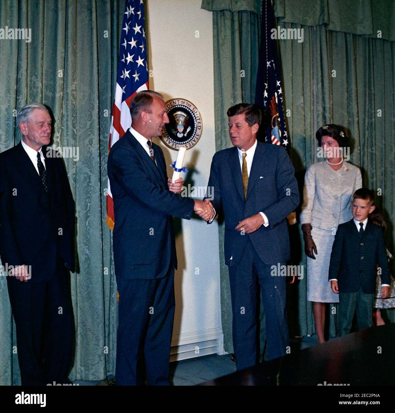 Giuramento in cerimonia, William Battle, Ambasciatore degli Stati Uniti in Australia, 17:14. Il presidente John F. Kennedy scuote le mani con il neo-nominato ambasciatore degli Stati Uniti in Australia, William C. Battle, durante la cerimonia di giuramento del sig. Battleu0027s. Da sinistra a destra: Ex Governatore della Virginia, John S. Battle; Battaglia dell'Ambasciatore; Presidente Kennedy; Battaglia di Barry Webb; Battaglia di Robert W. Sala armadio, Casa Bianca, Washington, D.C. Foto Stock