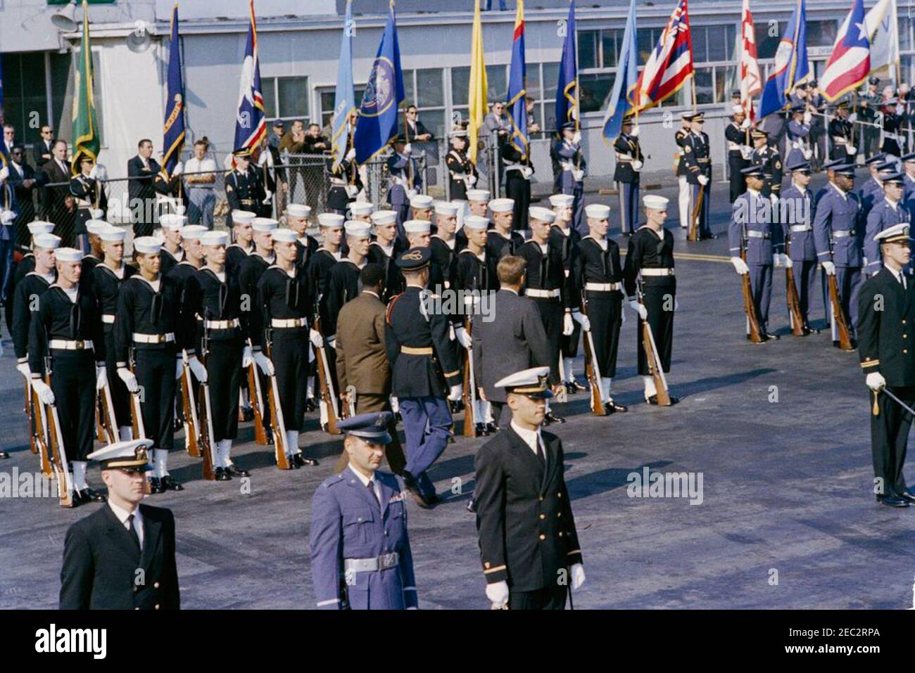 Cerimonia di arrivo per Ahmed Su00e9kou Touru00e9, Presidente della Guinea, ore 11:00. Il presidente John F. Kennedy e il presidente della Guinea, Ahmed Su00e9kou Touru00e9 (entrambi con le spalle alla macchina fotografica), rivedono le truppe di guardia d'onore durante le cerimonie di arrivo per il presidente Touru00e9; un comandante non identificato delle truppe cammina con i presidenti. Terminal del Servizio militare di trasporto aereo (MATS), Aeroporto Nazionale di Washington, Washington D.C. Foto Stock