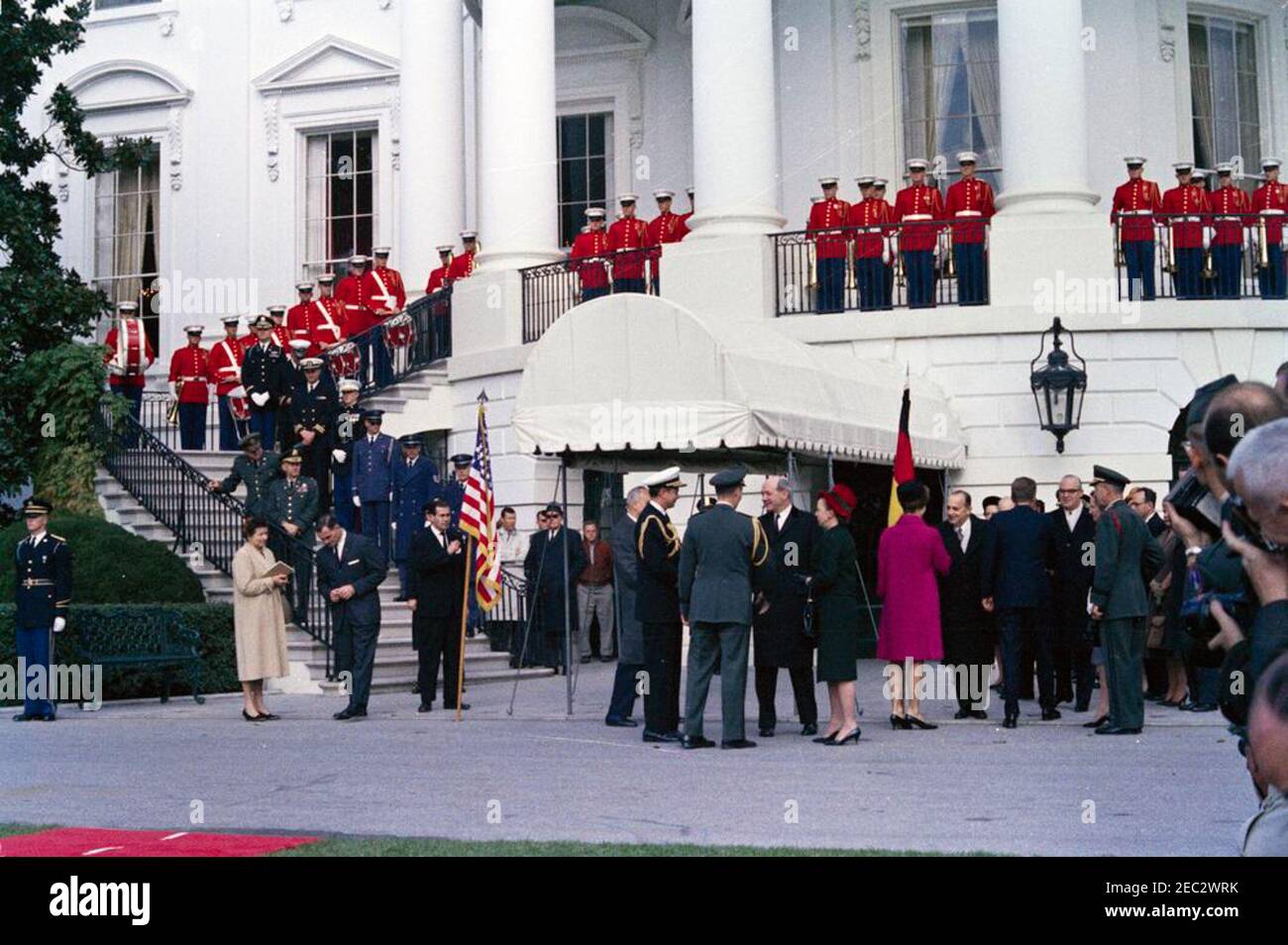 Cerimonie di arrivo per Konrad Adenauer, Cancelliere della Germania Occidentale, 10:45. Il presidente John F. Kennedy e altri attendono l'arrivo del Cancelliere della Germania occidentale, Dr. Konrad Adenauer, alla Casa Bianca. Il presidente Kennedy (a destra, di nuovo alla macchina fotografica) saluta l'ambasciatore della Germania occidentale, Karl Heinrich Knappstein; la prima signora Jacqueline Kennedy scuote le mani con l'ambasciatore del Nicaragua e decano del corpo diplomatico, il Dott. Guillermo Sevilla-Sacasa. Anche nella foto: Presidente dei Capi congiunti del personale, Generale Maxwell D. Taylor; Lydia Taylor; Vice Capo del protocollo, William J. Tonesk; Segretario degli Stati Uniti Foto Stock