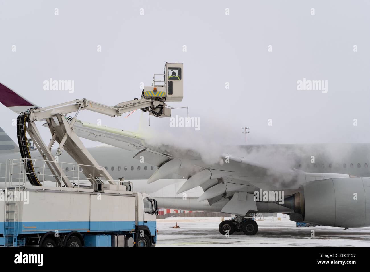 Scongelamento dell'aereo prima del volo. La macchina per lo sbrinamento  spruzza antigelo sull'ala di un aereo passeggeri. Inverno all'aeroporto.  Neve. AVI Foto stock - Alamy