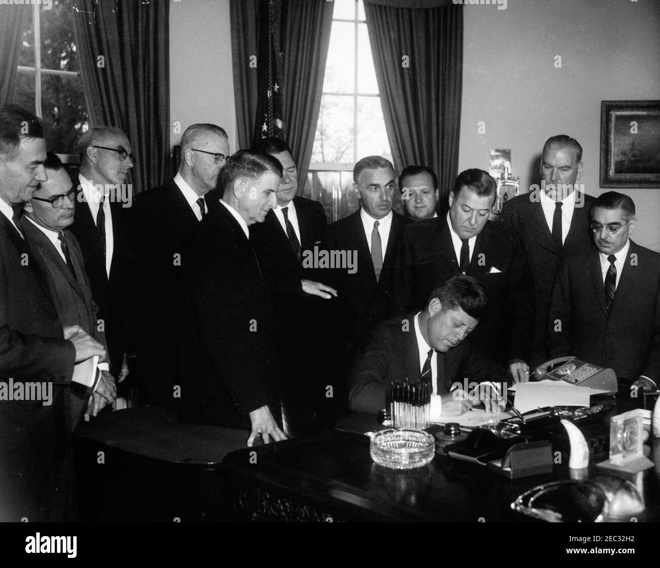 205 Legge pubblica 87-447, Legge sulla Televisione educativa, 12:00 PM. Il presidente John F. Kennedy (seduto) firma la legge sulla televisione educativa. In piedi (L-R): Senatore Clifford P. Case (New Jersey); congressista John E. Moss (California); non identificato; senatore Norris Cotton del New Hampshire (volto oscurato); congressista Oren Harris (Arkansas); congressista Hale Boggs (Louisiana); Segretario di Salute, Educazione e benessere, Abraham Ribicoff; avvocato G. Leonard, (Warren); magnate, Washington (Marks H. Springer (Illinois); il senatore John O. Pastore (Rhode Island Foto Stock