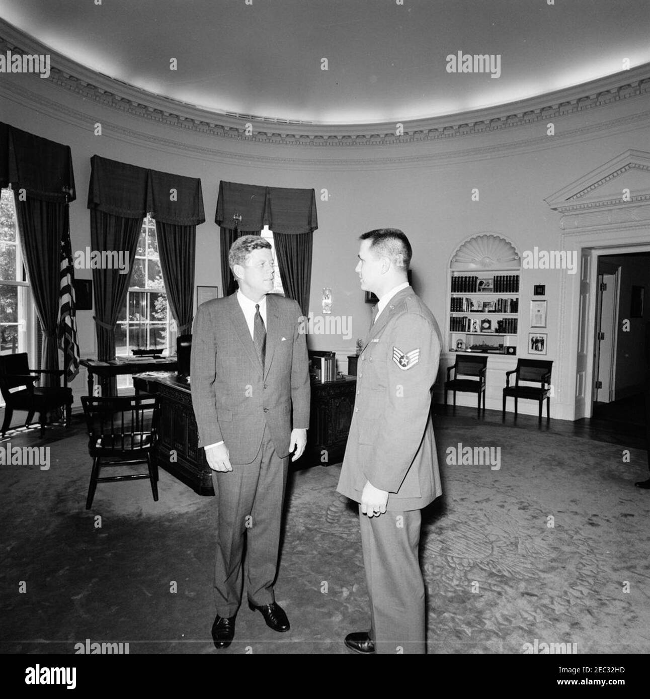 Il presidente Kennedy con SSgt. Staymes, United States Air Force (USAF). Il presidente John F. Kennedy visita con un uomo identificato nel registro photographeru2019s come sergente Staymes (destra), dell'aeronautica degli Stati Uniti. Ufficio ovale, Casa Bianca, Washington, D.C. Foto Stock