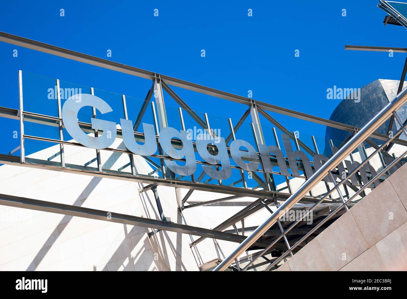 Europa, Spagna, Paesi Baschi, Bilbao, Museo Guggenheim Bilbao con cartello sul tetto vicino all'ingresso principale Foto Stock