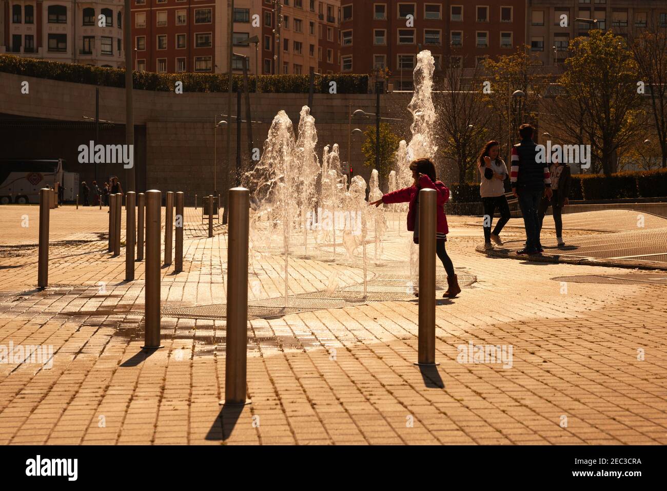 Europa, Spagna, Paesi Baschi, Bilbao, Bambini che giocano con le fontane vicino al Museo Guggenheim Foto Stock