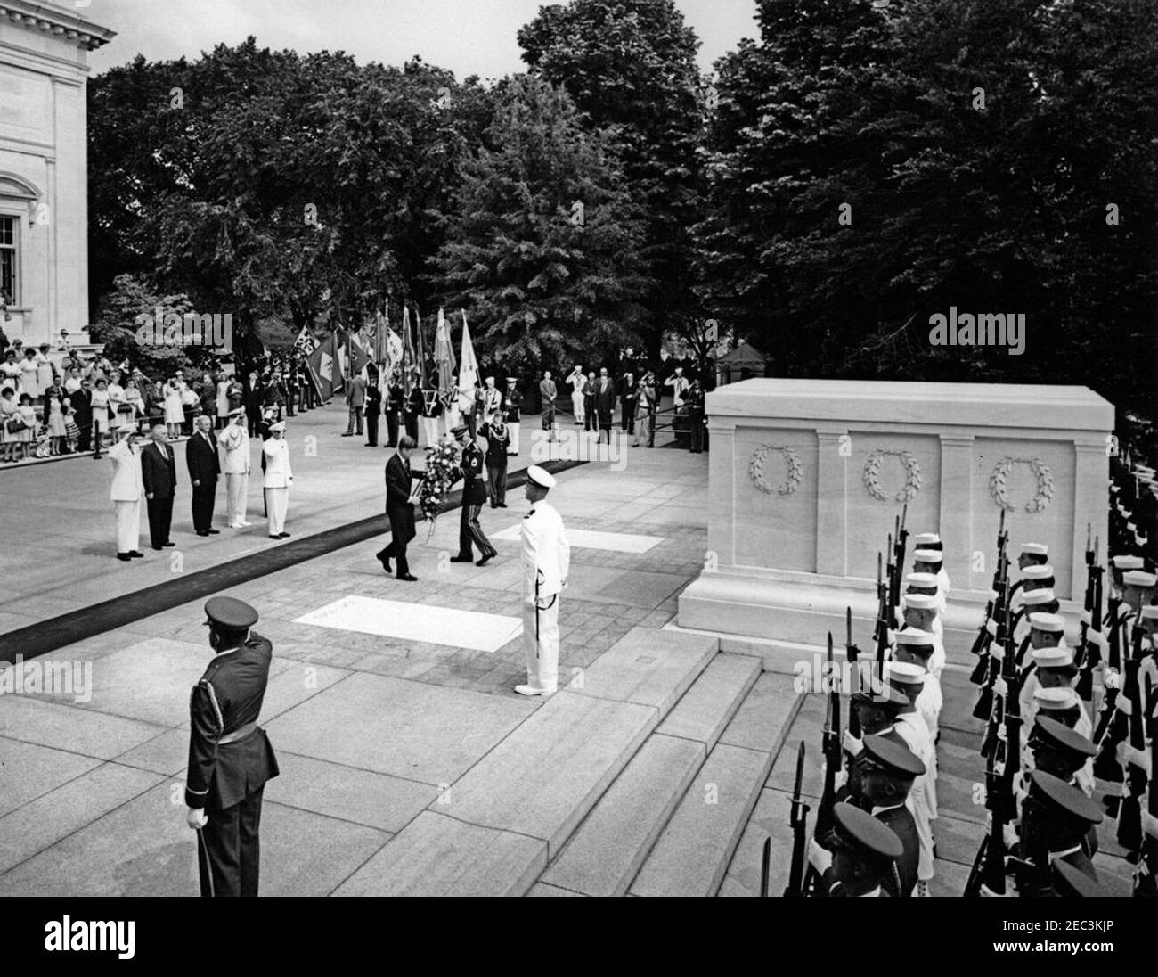 Cerimonie del Memorial Day presso il cimitero nazionale di Arlington, ALLE 10:50. Come parte delle cerimonie del Memorial Day al cimitero nazionale di Arlington ad Arlington, Virginia, il presidente John F. Kennedy (a sinistra, assistito dal sergente Allen Eldredge) porta una corona da collocare alla tomba del Milite Ignoto, sui gradini dell'Arlington Memorial Amphitheatre. Alle spalle del presidente Kennedy (L-R): Generale Maxwell D. Taylor; Amministratore della Veterans Administration (VA), generale John S. Gleason; ex ambasciatore degli Stati Uniti in Irlanda, Grant Stockdale; Naval Aide al presidente, Capitano Tazewell Shepar Foto Stock