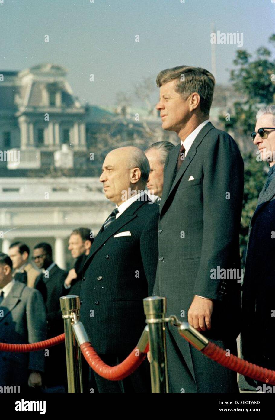 Cerimonia di arrivo del primo Ministro italiano Amintore Fanfani, ore 11:15. Il Presidente John F. Kennedy partecipa alle cerimonie di arrivo del primo Ministro italiano Amintore Fanfani. In primo piano (L-R): Primo Ministro Fanfani; Ambasciatore d'Italia negli Stati Uniti, Sergio Fenoaltea (a ritroso, parzialmente nascosto); Presidente Kennedy; Sottosegretario agli Affari Esteri d'Italia, Edoardo Martino. Eddie N. Williams, ufficiale del protocollo del Dipartimento di Stato, si trova sullo sfondo (indossando gli occhiali); capo Assistente del protocollo per visite ed eventi pubblici, Samuel L. King, si trova a destra di MR. Williams. Prato Sud, Whi Foto Stock