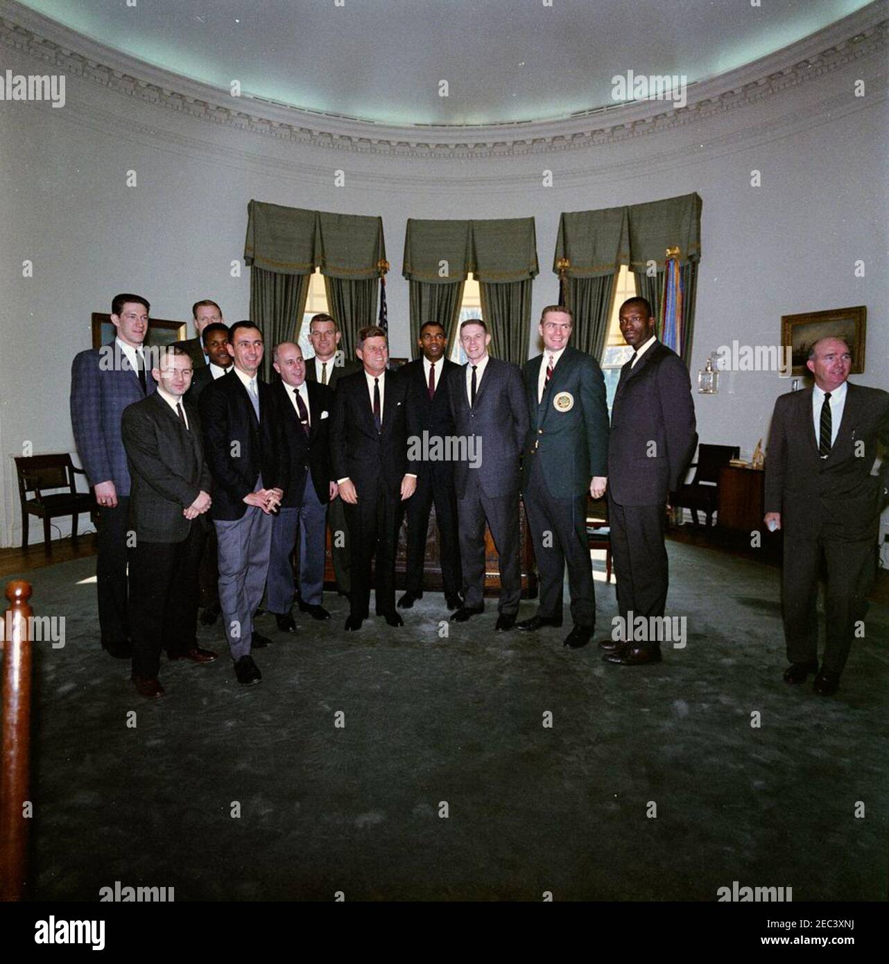 Visita della squadra di pallacanestro dei Boston Celtics alle 13:00. I membri della Nazionale Basketball Association (NBA) la squadra dei Boston Celtics visita con il Presidente John F. Kennedy nell'Ufficio ovale durante un tour della Casa Bianca. (L-R) Edward G. u0022Buddyu0022 Leroux, Jr.; John Havlicek (sul retro); Bob Cousy; K. C. Jones (parzialmente nascosto dietro il Sig. Cousy); Clyde Lovellette (sul retro); Coach Red Auerbach; Jim Loschutoff (sul retro); Presidente Kennedy; Sam Jones; Frank Ramsey; Tom Heinsohn e Tom Sanders. L'Assistente speciale del Presidente Dave Powers si trova all'estrema destra. Washington, D.C. Foto Stock