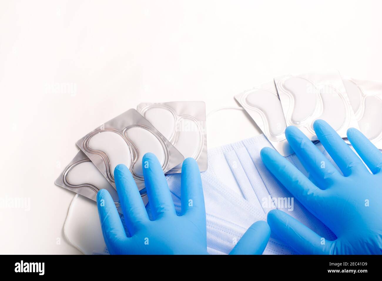 Accessori di bellezza su sfondo bianco. Guanti, maschere e cerotti blu. Foto Stock