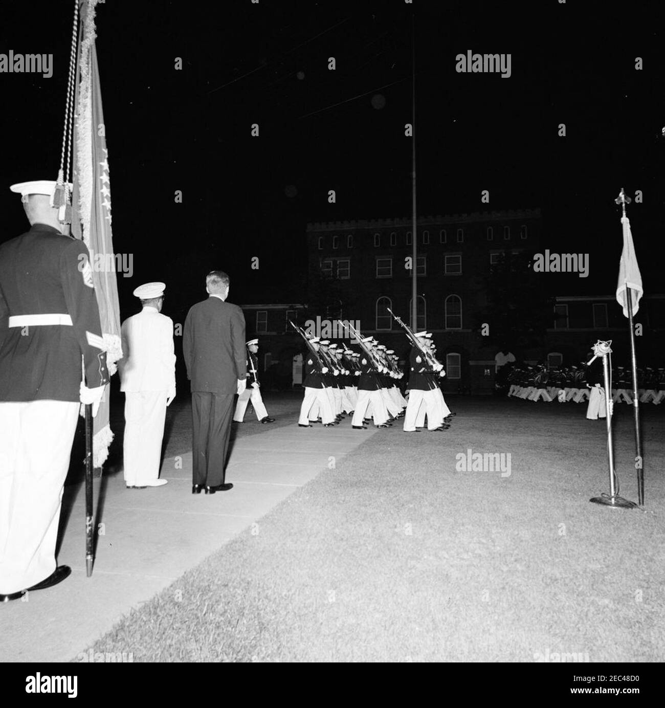 Il Presidente Kennedy vede la Marine Corpsu0027 Evening Parade, presso le Marine Barracks Washington, D.C. (8th u0026 i Streets, se), alle 21.00. Il presidente John F. Kennedy (torna alla fotocamera) guarda i membri della Guardia a colori del corpo dei Marini marcia durante una parata serale alle Barracks Marine (u201c8th u0026 Iu201d) a Washington, D.C. Comandante del corpo dei Marini degli Stati Uniti, il generale David M. Shoup (indossando il bianco), si trova accanto al presidente Kennedy. Foto Stock