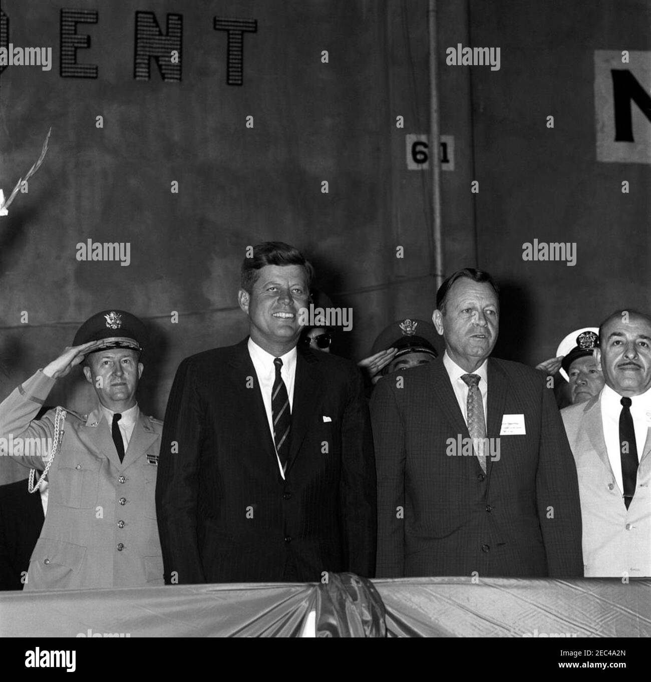 Viaggio in Louisiana e Florida: New Orleans, Louisiana, indirizzo al Nashville Avenue Wharf Dedication, 10:30. Il presidente John F. Kennedy partecipa a una cerimonia di dedizione per Nashville Avenue Wharf, un nuovo terminal portuale al porto di New Orleans a New Orleans, Louisiana. Da sinistra a destra: Aide militare al presidente, generale Chester V. Clifton; presidente Kennedy; governatore della Louisiana, James u201cJimmieu201d Davis; uomo non identificato (in dietro); sindaco di New Orleans, Victor H. u201cVicu201d Schiro. [Fotografia di Harold Sellers] Foto Stock