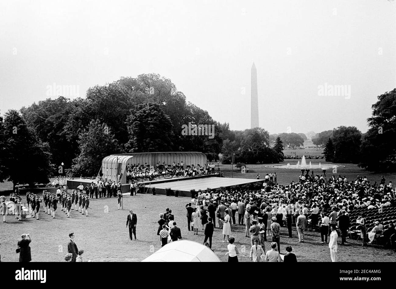 First Lady Jacqueline Kennedyu0027s (JBK) programma musicale per la gioventù, 10:35. Ampia vista del Prato Sud durante la quarta in prima Lady Jacqueline Kennedyu2019s serie di programmi musicali per la Gioventù. I membri della National High School Symphony Orchestra del National Music Camp di Interlochen, Michigan, siedono sul palco al centro a sinistra; i ballerini di balletto (anche dal campo di musica) si trovano dietro il palco all'estrema sinistra; I membri della Old Guard Fife e Drum Corps, 1° Battaglione, 3° reggimento di fanteria (parte della u201cOld Guardu201d), si trovano a sinistra in primo piano. Il Washin Foto Stock