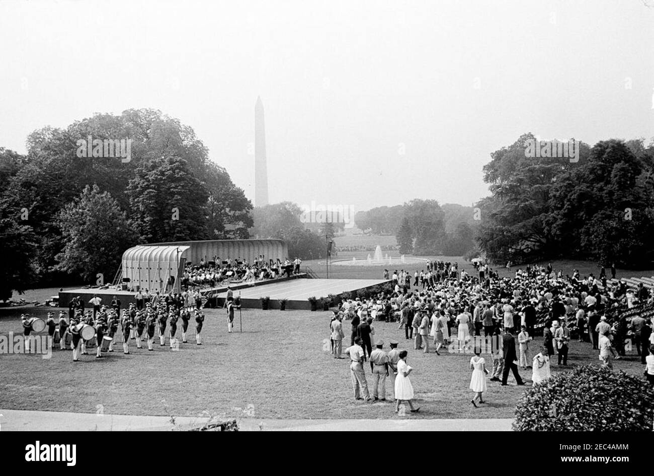 First Lady Jacqueline Kennedyu0027s (JBK) programma musicale per la gioventù, 10:35. Ampia vista del Prato Sud durante la quarta in prima Lady Jacqueline Kennedyu2019s serie di programmi musicali per la Gioventù. I membri della National High School Symphony Orchestra del National Music Camp di Interlochen, Michigan, siedono sul palco al centro a sinistra; i membri della Old Guard Fife e Drum Corps, 1° Battaglione, 3° reggimento fanteria (parte della u201cOld Guardu201d), si trovano a sinistra in primo piano. Il Washington Monument e il Jefferson Memorial sono visibili in lontananza. White House, è stato Foto Stock
